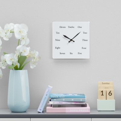 Square Spelling Bee Clock above books and an orchid