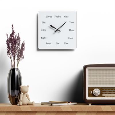 Square Spelling Bee Clock above a shelf with a vase and radio